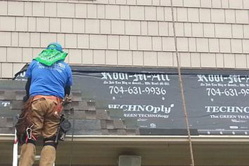 man laying roofing